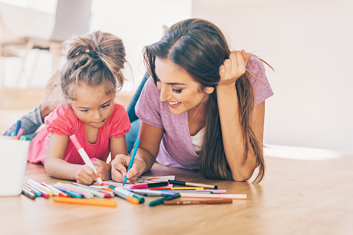 Mother and daughter coloring pages on the floor