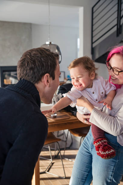 bebé riendo con su padre en reunión familiar. - 18 23 meses fotografías e imágenes de stock