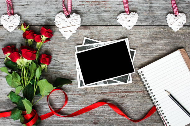 istock blank photo frame and notebook with red roses 641205186