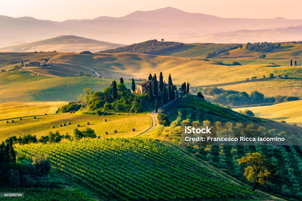 Val d'Orcia, Tuscany, Italy Val d'Orcia, Tuscany, Italy. A lonely farmhouse with cypress and olive trees, rolling hills. Tuscany Stock Photo