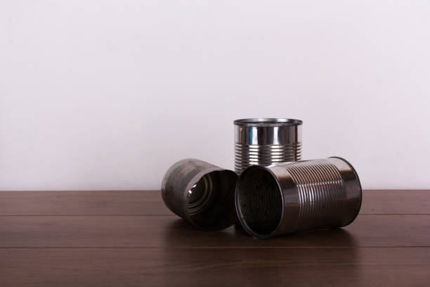 Battered tin cans on a wooden background stock photo