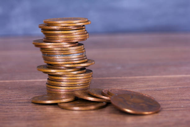 Stack of penny coins on a wooden surface stock photo
