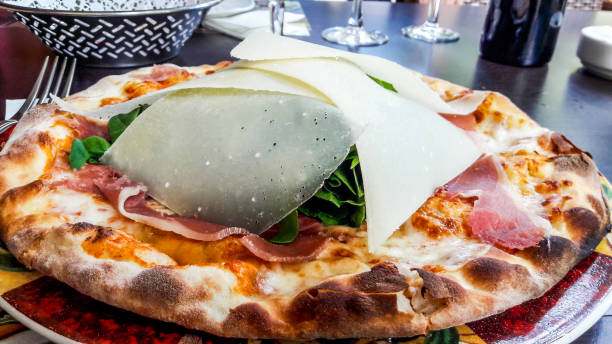 Carpaccio pizza with parmesan slices at restaurant. italian food concept.