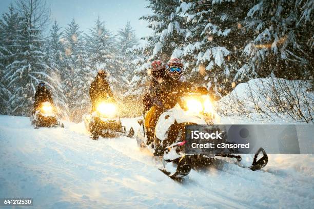 Couple Snow Mobile In Snow Storm Stock Photo - Download Image Now - Snowmobile, Snowmobiling, Winter