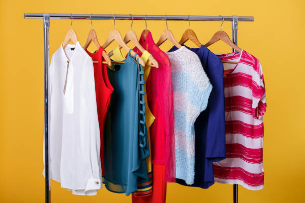 istock colorful womens clothes on hangers on rack on orange background. 641215072