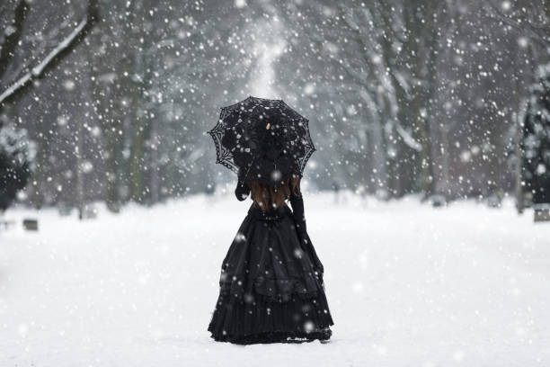 Mysterious lonely woman in Victorian dress departing into the distance stock photo