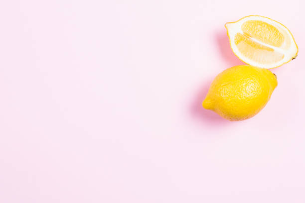 istock Whole and sliced lemon on pink background 641227958