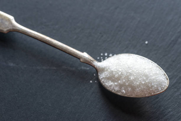 istock Spoon with white sugar on the dark background 641228284