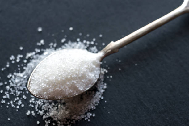 istock Spoon with white sugar on the dark background 641228788