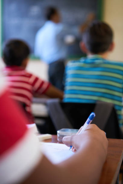 primo passo della scrittura della mano degli studenti su carta a scuola - child caribbean black latin american and hispanic ethnicity foto e immagini stock