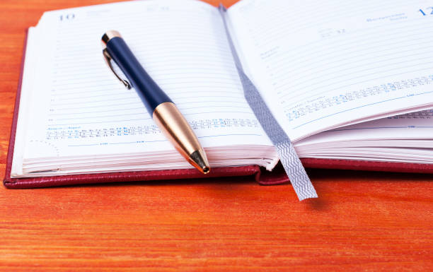 istock diary with a pen lying on a wooden table 641237832