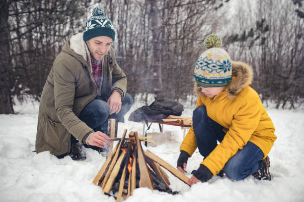 istock Father and son making campfire on the snow 641238614