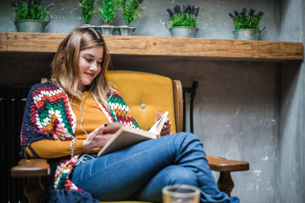 istock Woman sitting at the table in cafe and reading book. 641240292