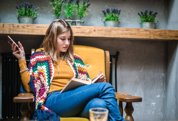 istock Woman sitting at the table in cafe and reading book. 641240630