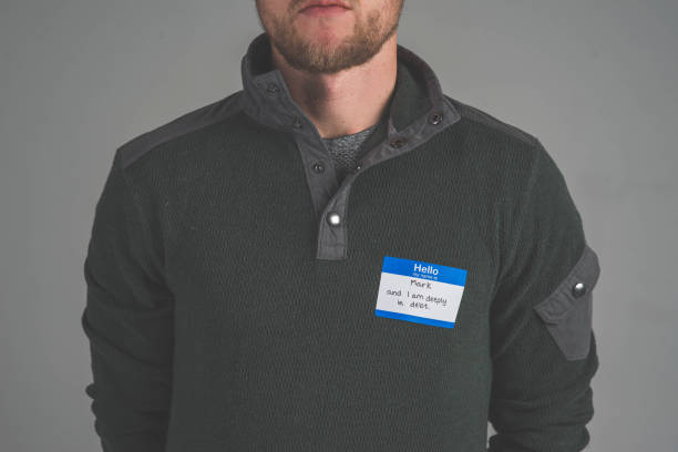 istock Young man facing audience with name tag that describes struggle 