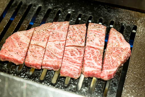 Sizzling beef slices grill on charcoal, Korean or Japanese BBQ style cuisine. Selective focus