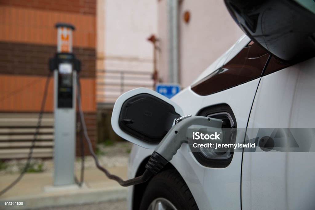 Electric Car Charging At Public Station Electric Car Charging at Public Charging Electric Car Stock Photo