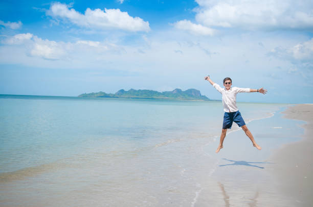 istock Business man working with laptop and smartphone beach background 641247894
