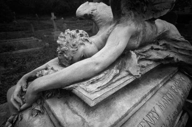 istock Statue of a weeping angel laying over an ancient grave 641252004
