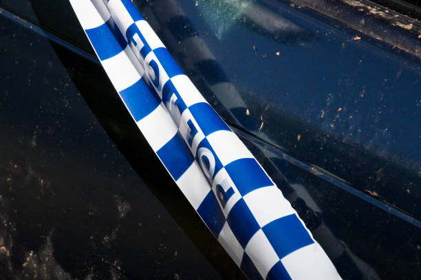 Police tape on abandoned crashed vehicle stock photo