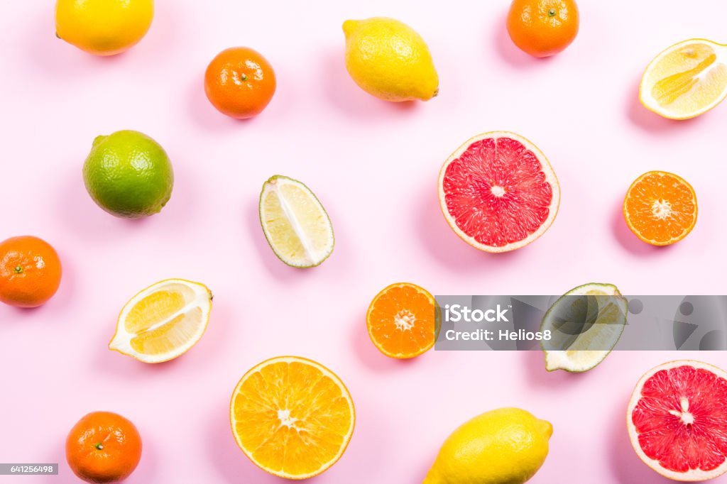 Several kinds of whole and cut citrus on a pink background Several kinds of whole and cut citrus on a pink background. Top view Fruit Stock Photo