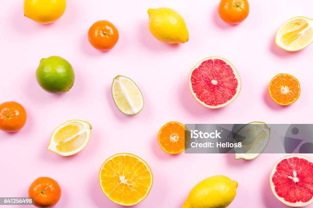 Several Kinds Of Whole And Cut Citrus On A Pink Background Stock Photo - Download Image Now