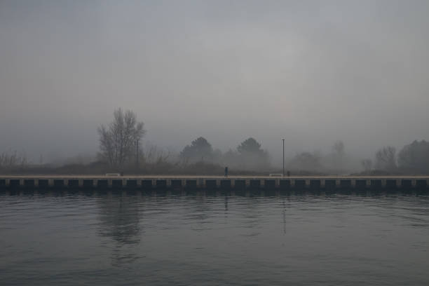 istock Man walks alone along a dock in a foggy day 641257534