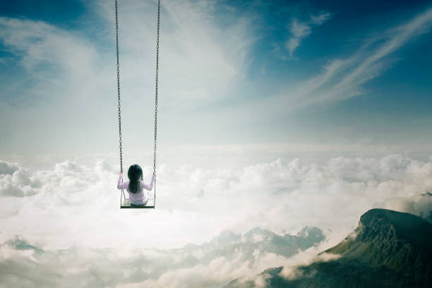 istock Little daughter swinging above clouds 641257738