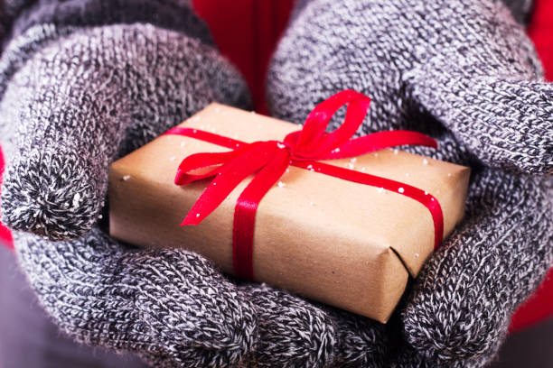 istock Open hands holding a present wrapped with a red ribbon 641261202
