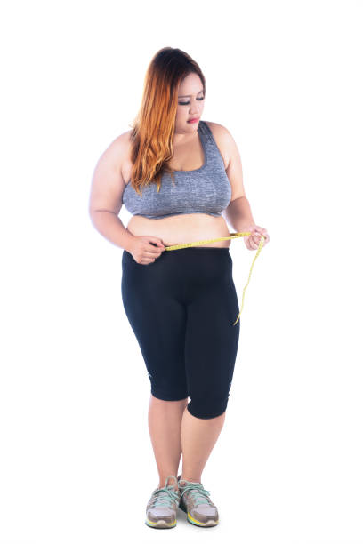 istock Fat woman measures her belly on studio 641261812