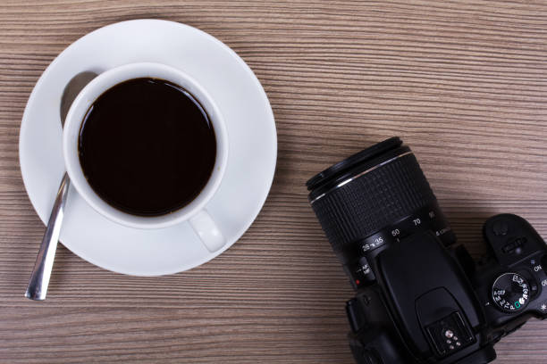 istock Coffee cup and camera on a wooden surface 641264750