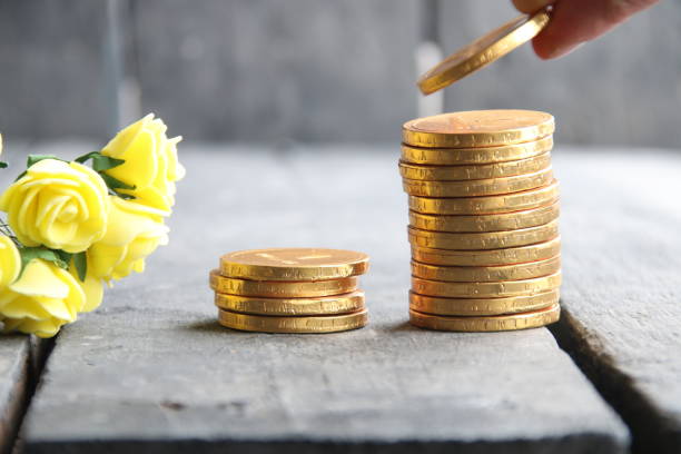 hand holding gold coins and nice flowers Hand putting stack of gold coins, vintage style gold ira services stock pictures, royalty-free photos & images