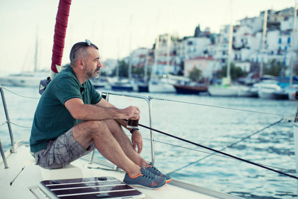 istock Man sitting on sailboat's bow and enjoying 641267458