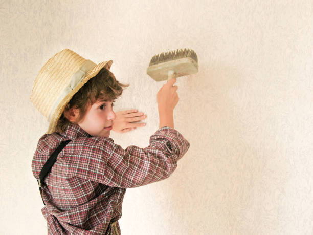 istock Small boy paints the wall. Child labour concept. Tired boy painter is very tired after work.Tired schoolchild in shirt sleeping on the floor. Black and white photo. Children worker. Stop child labour 641267490