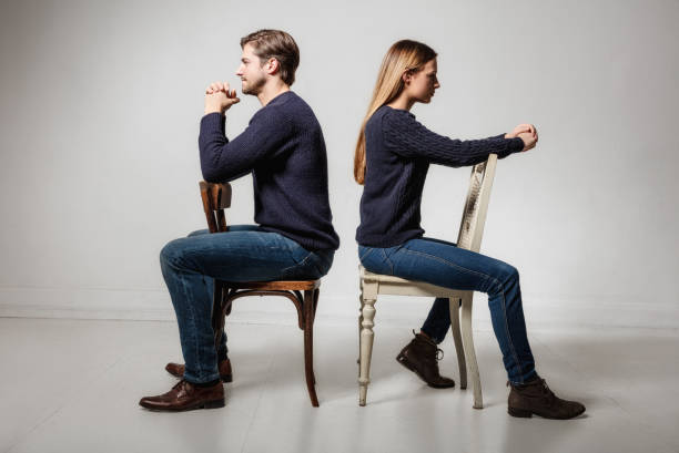 istock couple sitting back to back on chairs 641272568