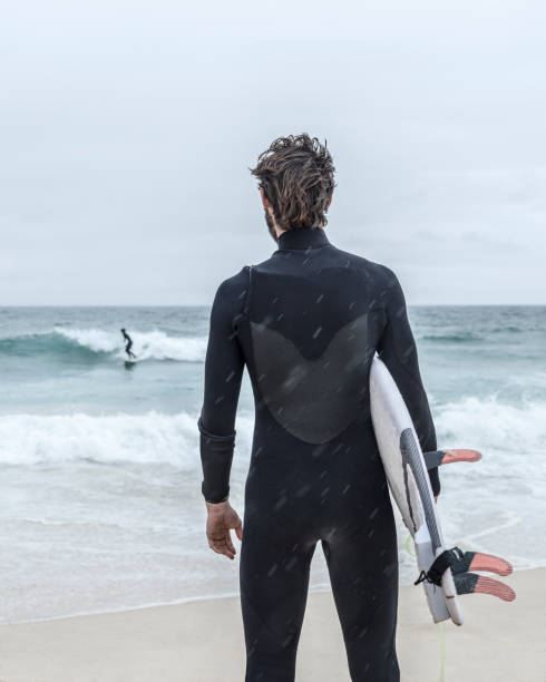 istock Rear view of surfer on beach with sea in background 641274808