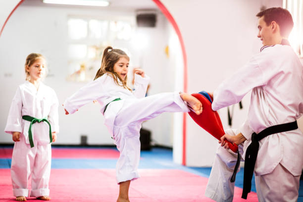 istock Two cute girls on taekwondo training, kicking and learning self-defence 641278672