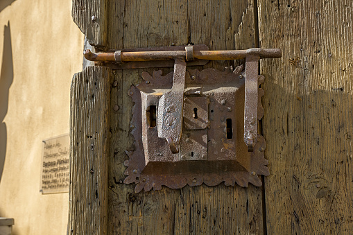 Ancient lock with latch on aged boarded door.