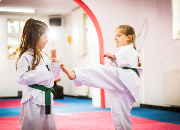 istock Two cute girls on taekwondo training, kicking and learning self-defence 641279700