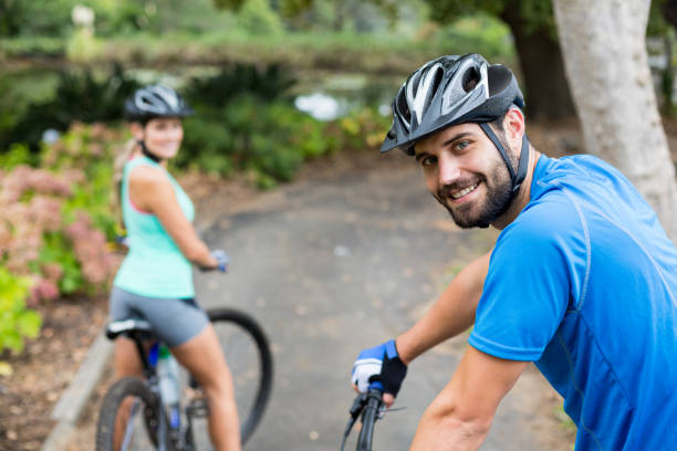 istock Smiling athletic couple standing with mountain bike in forest 641283732