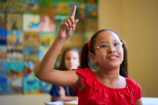 istock Female Student Raising Hand During Test In Class At School 641286344