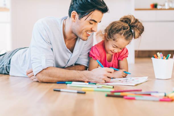istock Father and daughter coloring on the floor 641287928