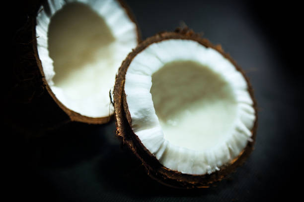 Fresh broken coconut on dark background studio shot