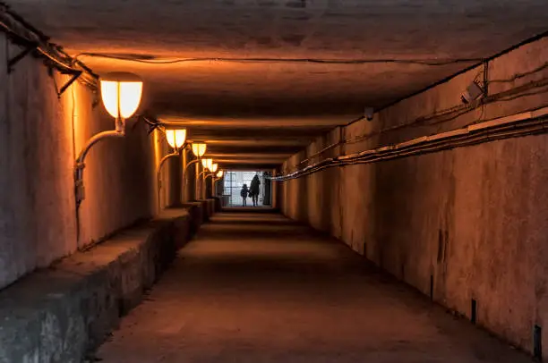 Photo of Mother and child crossing a subterranean passage