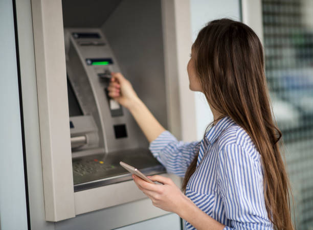 istock Young woman taking money from ATM 641296678