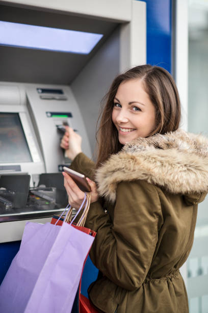 istock Young woman taking money from ATM 641297266