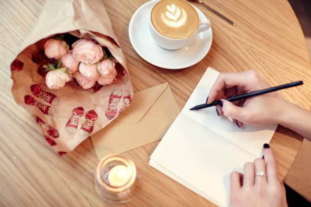 istock Woman writing at notebook blank layout Flowers and coffee 641305092
