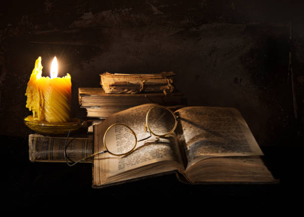 Still life with book, candle and glasses