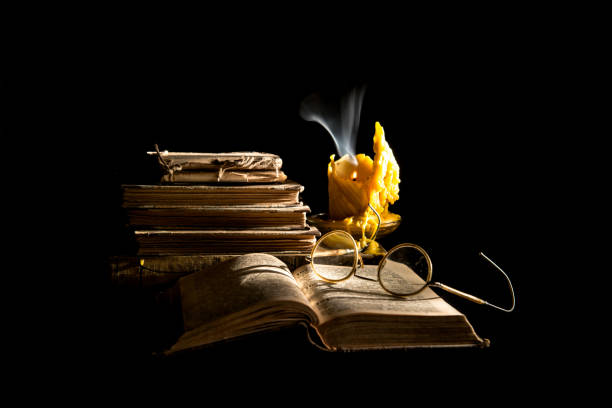 Burning spa aroma candles in coconut shell, pillows, plaid and books, cozy home interior. background