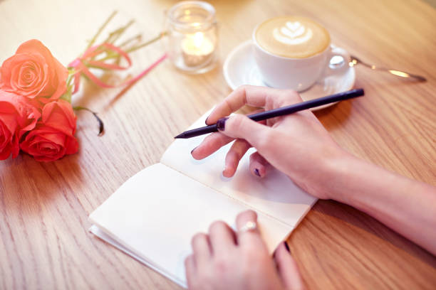 istock Woman hands writing in notebook, pencil, coffee, Flowers 641306590